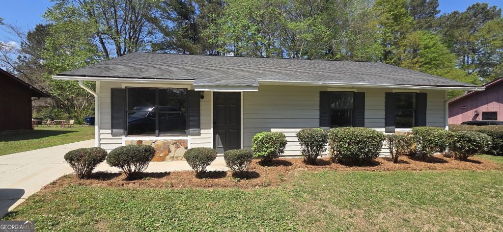 445-wilson-mill-rd-sw-atlanta-ga-front-exterior Exterior front view of a single-story ranch-style home at 445 Wilson Mill Rd SW, Atlanta, GA, featuring light siding, dark shutters, and professional landscaping.