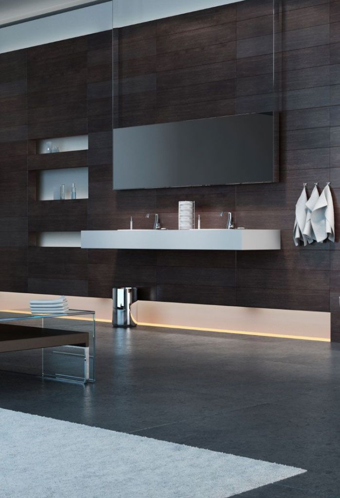 Modern luxury bathroom featuring dark wood-effect wall tiles, floating double vanity with white basin, large mirror, recessed shelving, and warm LED under-cabinet lighting