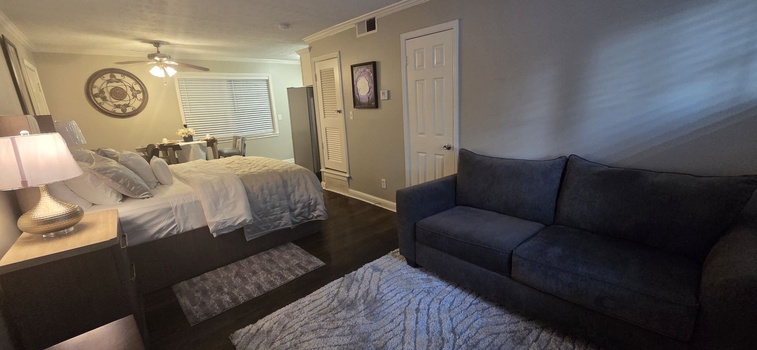 Wide view of modern studio suite featuring a queen bed and cozy seating area.
